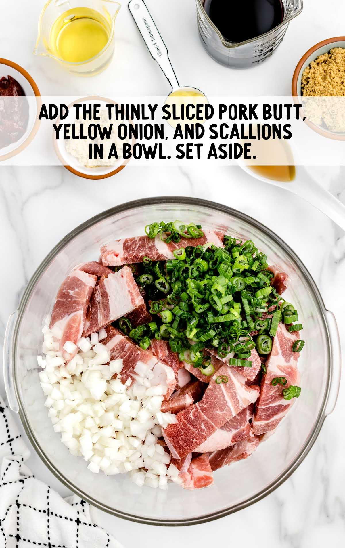 pork butt, chopped yellow onion, and chopped scallions combined in a bowl