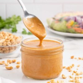 close up shot of Peanut Sauce Recipe in a jar with a spoon