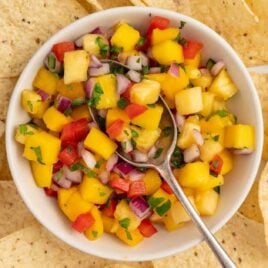 overhead shot of Pineapple Mango Salsa in a bowl with a side of chips