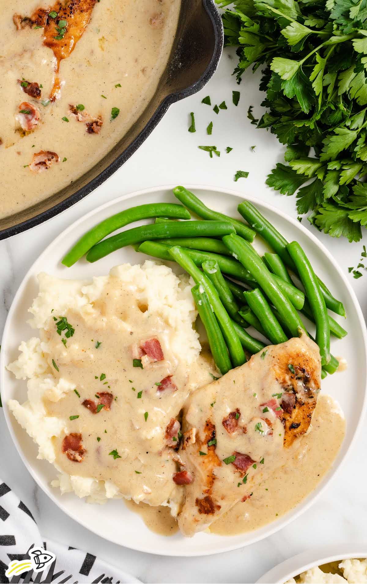 overhead shot of green beens, mashed potatoes and Smothered Chicken on a plate
