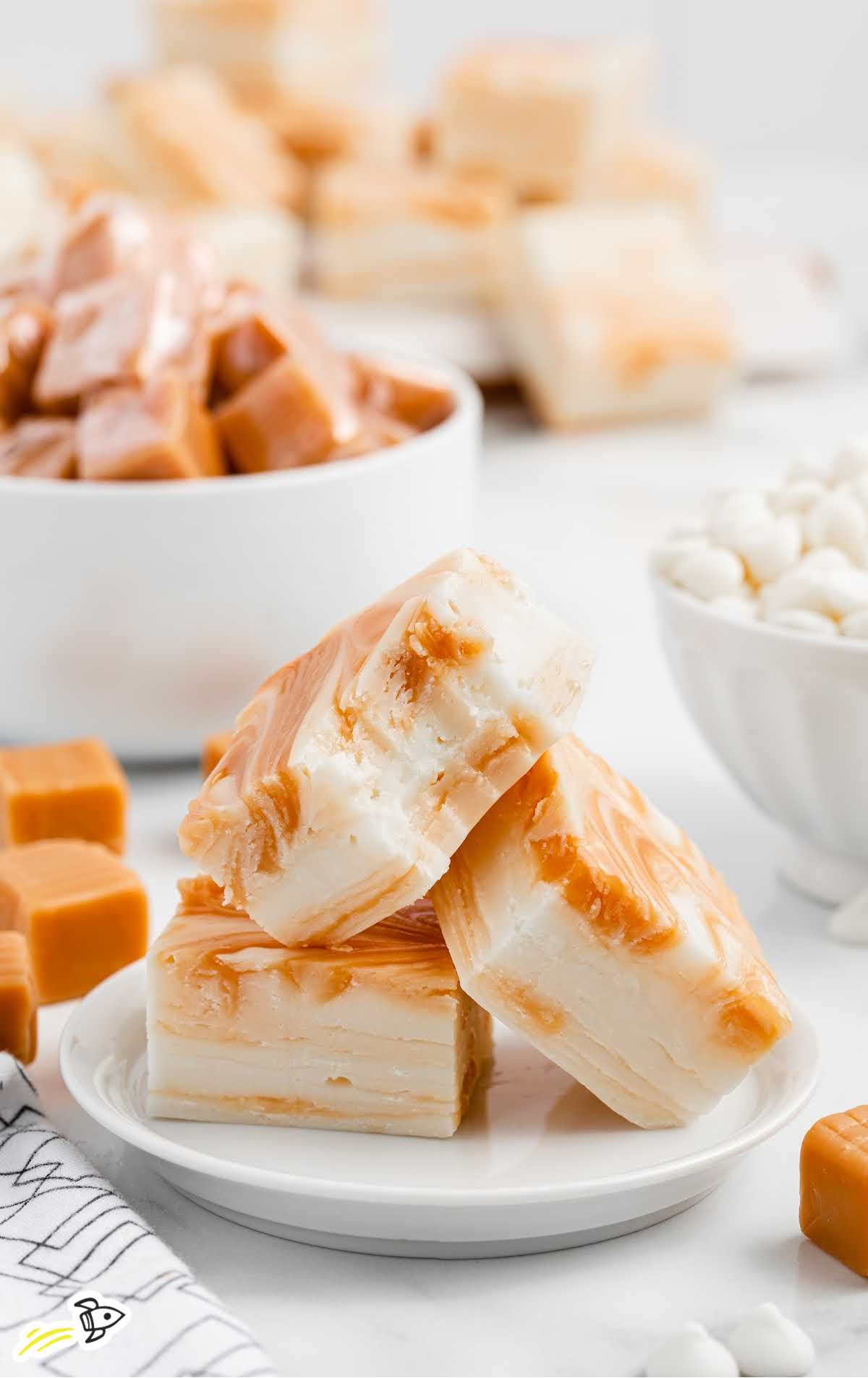 close up shot of White Chocolate Caramel Fudge pieces piled on a plate