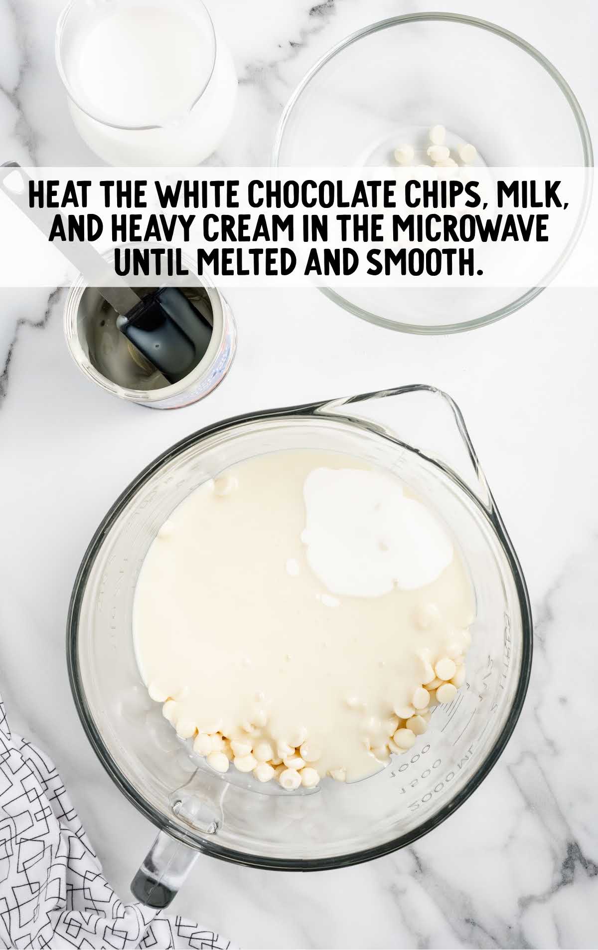 white chocolate chips, sweetened condensed milk, and heavy cream combined in a bowl