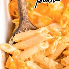 close up shot of a baking dish of Buffalo Chicken Pasta with a wooden spoon