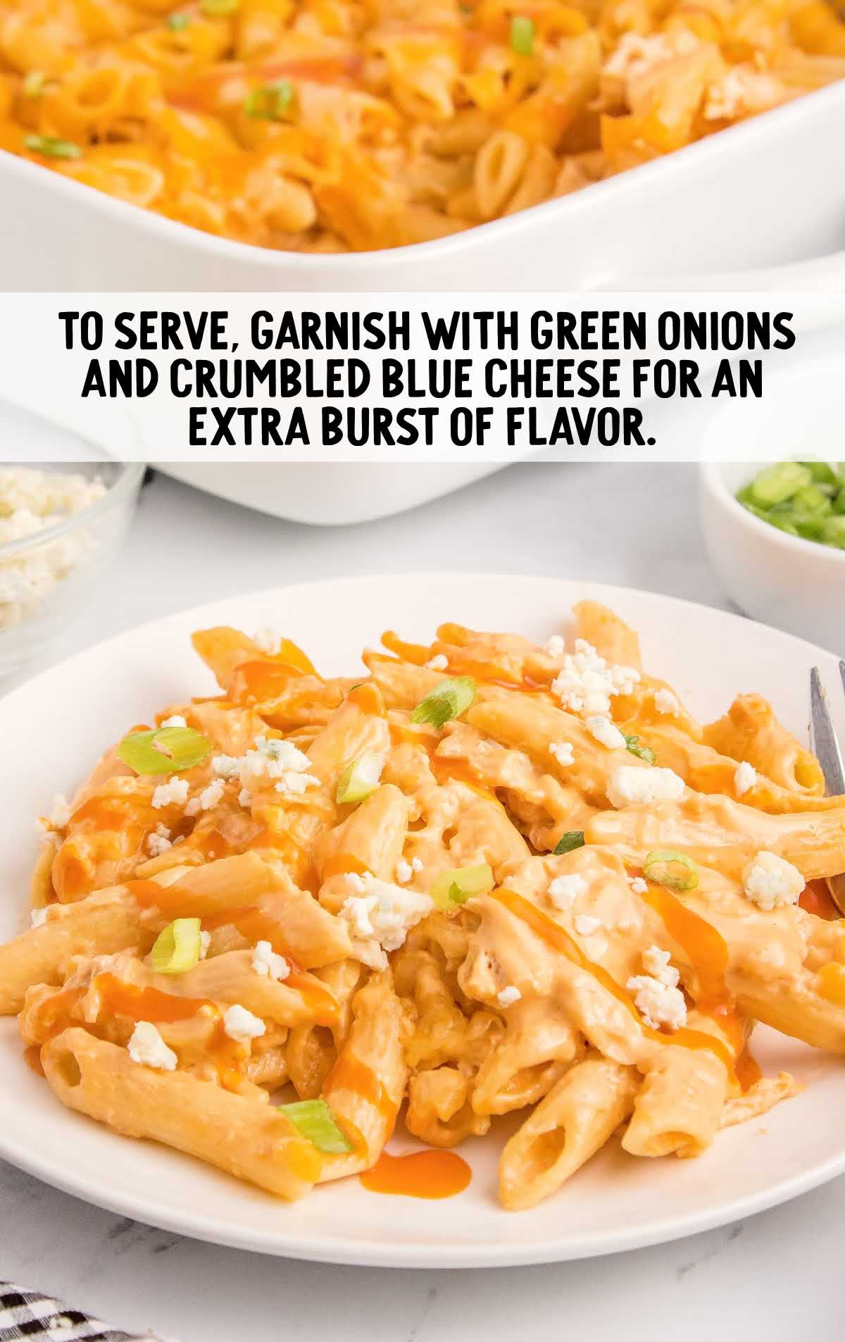 a plate of pasta garnished with green onions and blue cheese
