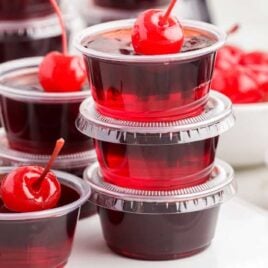a close up shot of Cherry Coke Jello Shots stacked on top of each other