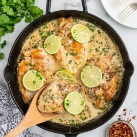overhead shot of a skillet of chicken topped with slices of lime