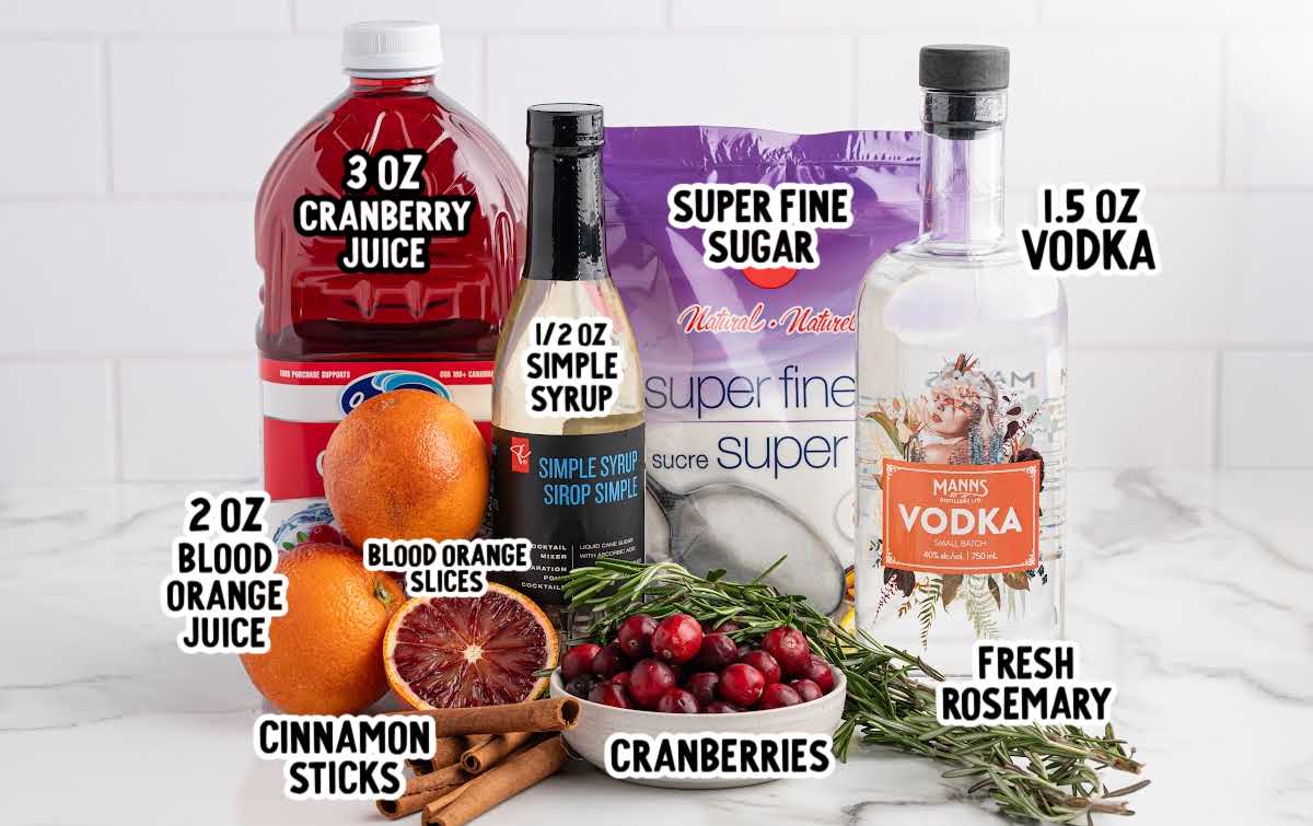 Ingredients for cranberry Christmas cocktail including cranberry juice, vodka, simple syrup, blood oranges, cranberries, rosemary, and cinnamon sticks.