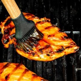 overhead shot of Fireball Chicken being brushed with sauce on a grill