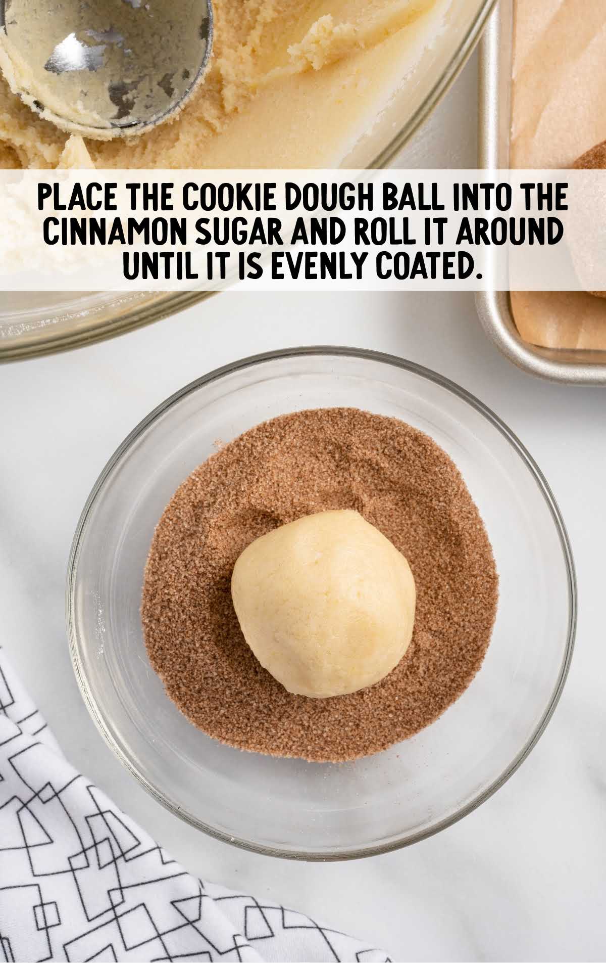 cookie dough balls rolled into a bowl of cinnamon sugar