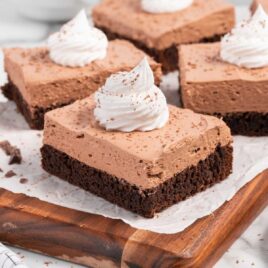 a close up shot of French Silk Brownies on a wooden cutting board