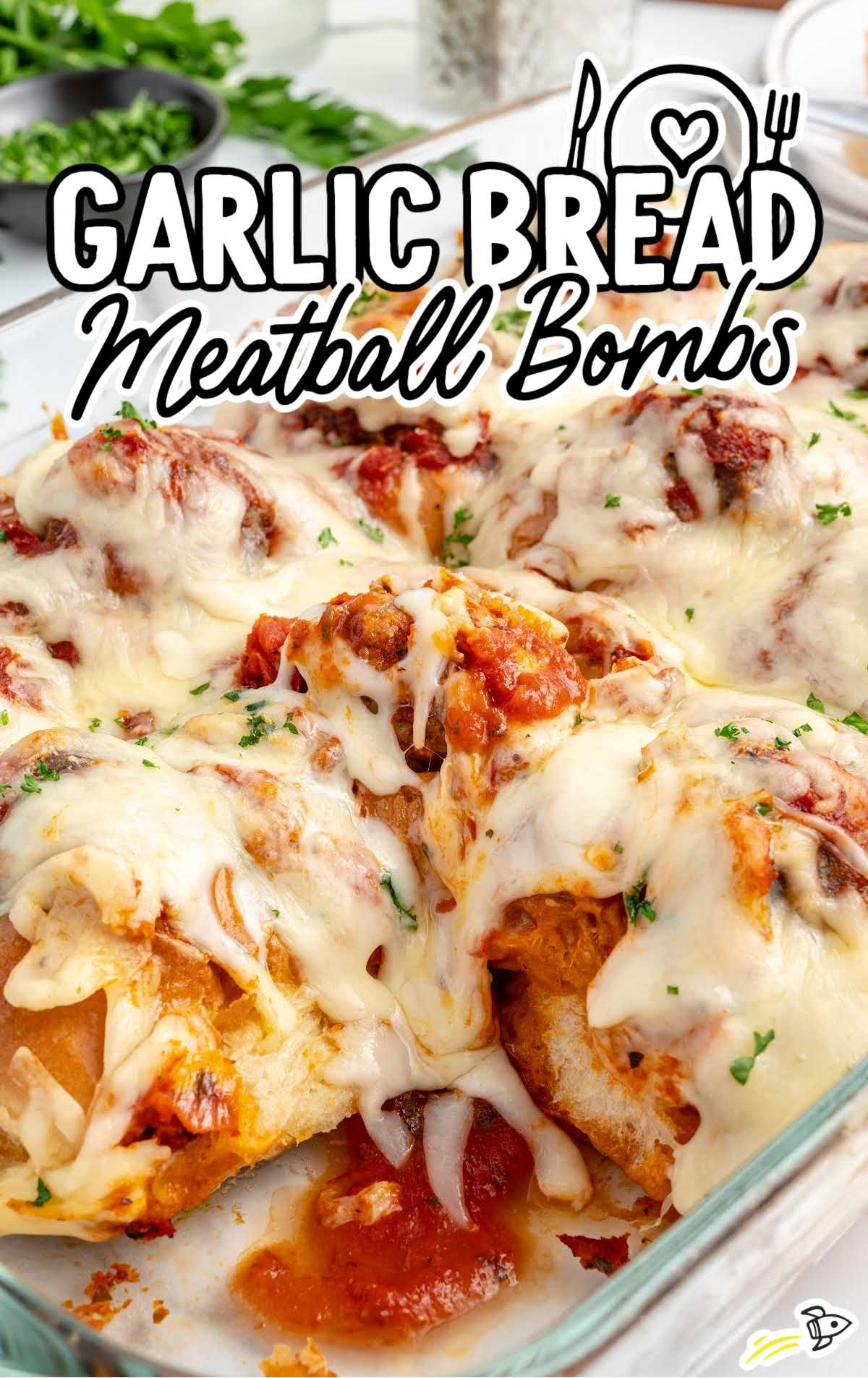 close up shot of garlic bread meatballs garnished with parsley in a baking dish