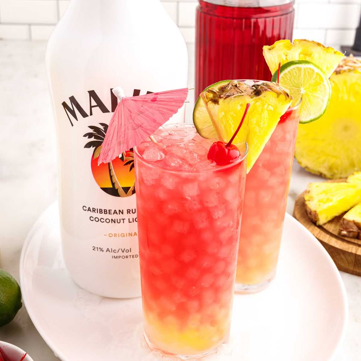 a close up shot of Malibu Cocktail garnished with a cherry, sliced pineapple, and a slice of lime