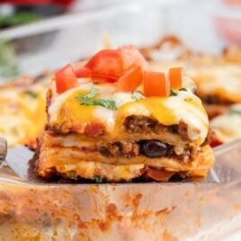 a close up shot of a slice of Mexican Lasagna on a spatula
