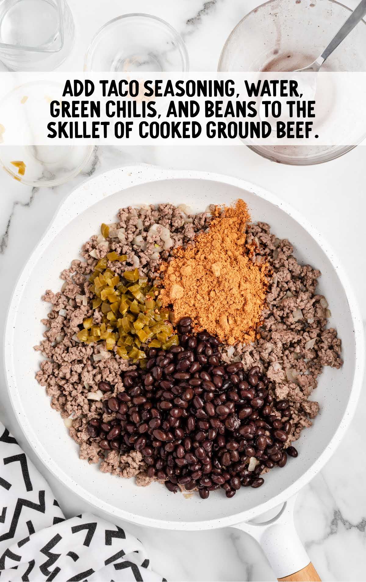 taco seasoning, water, green chilies, and beans added to the cooked ground beef