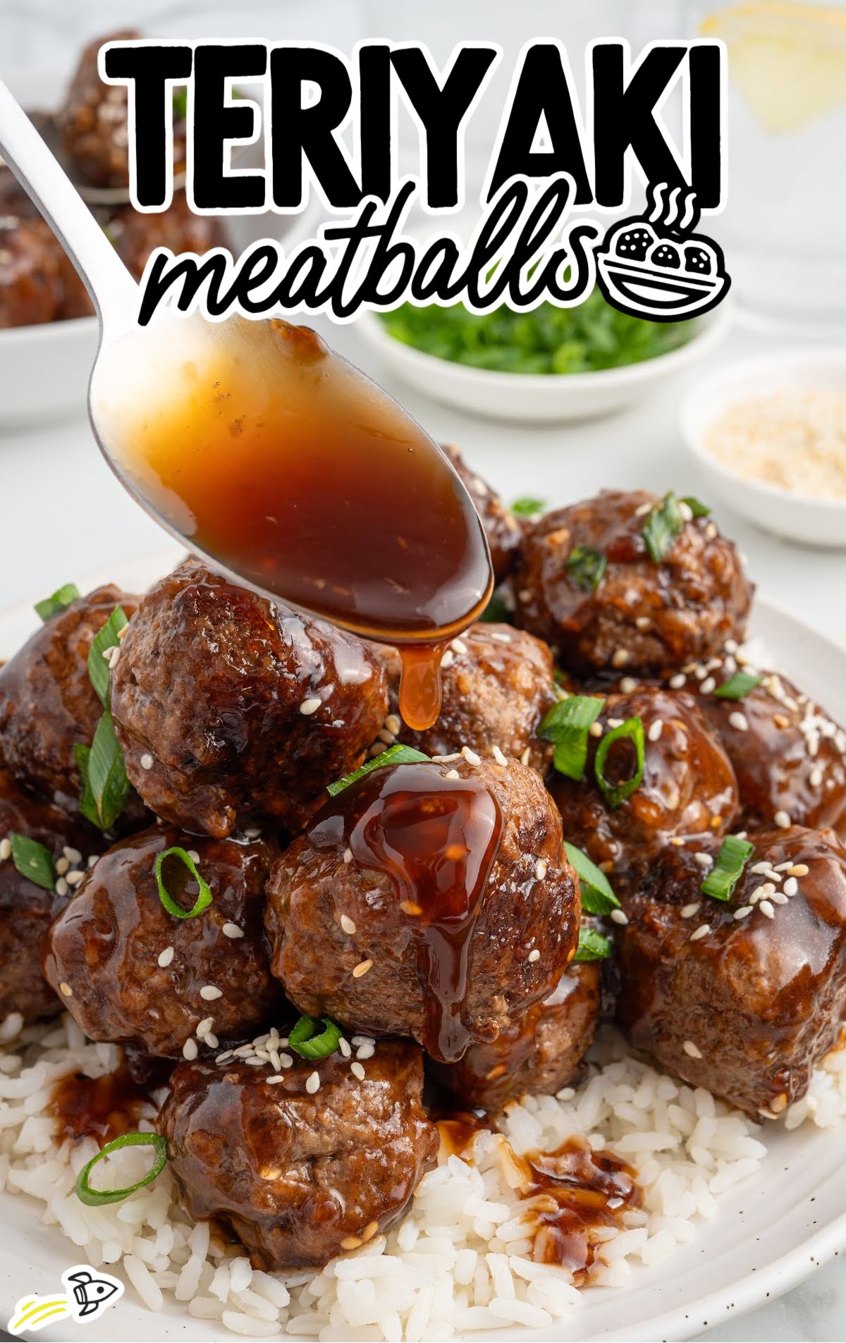 Spoon drizzling teriyaki sauce over juicy homemade meatballs on white rice