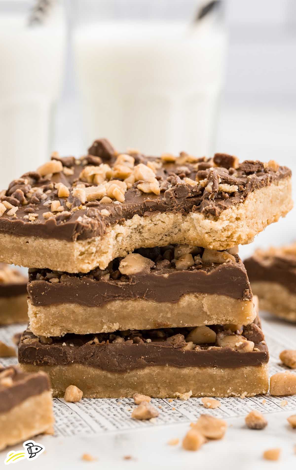 a close up shot of Toffee Bars stacked on top of each other with one having a bite taken out of it