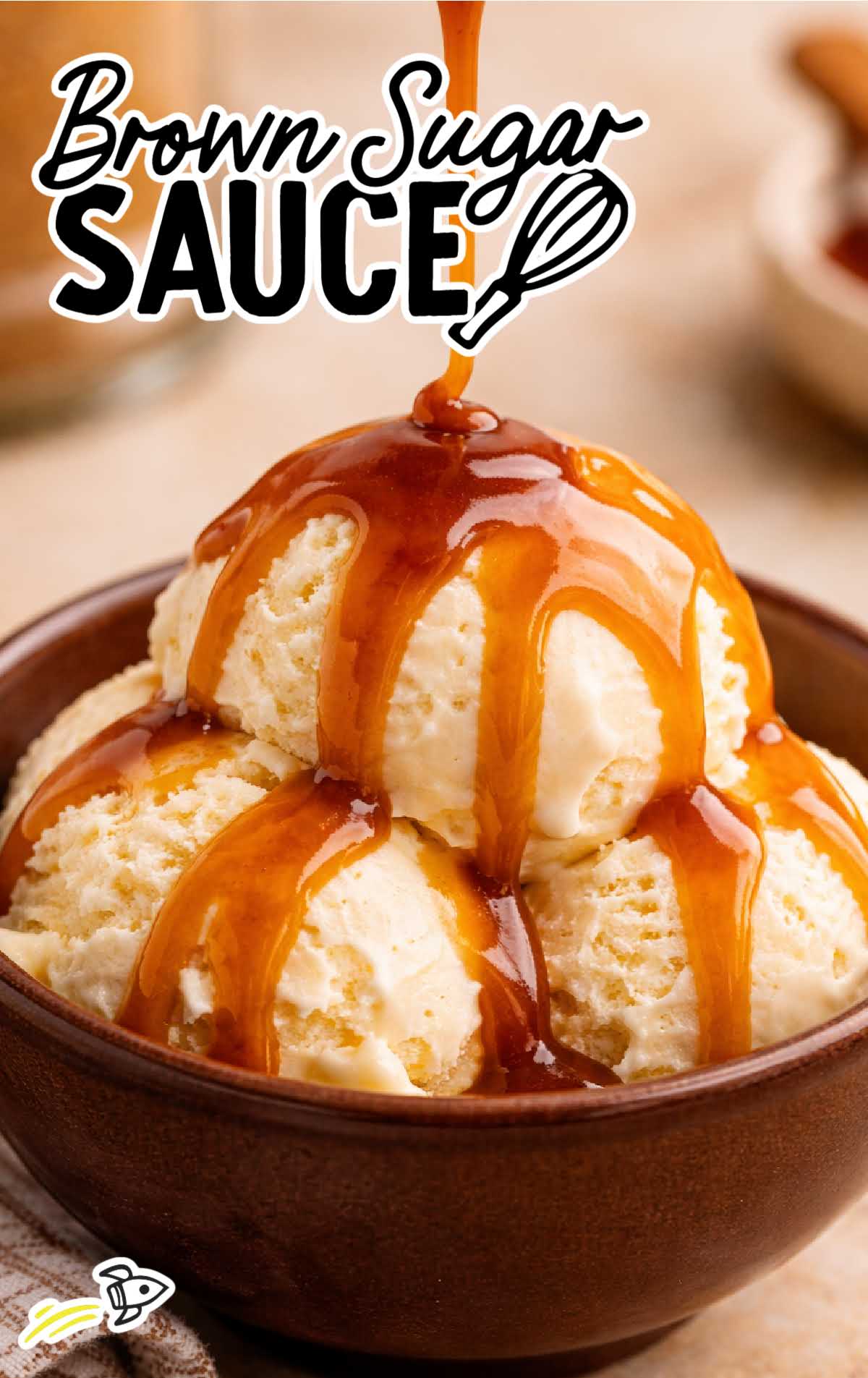 Brown sugar sauce poured over two scoops of vanilla ice cream in a brown bowl