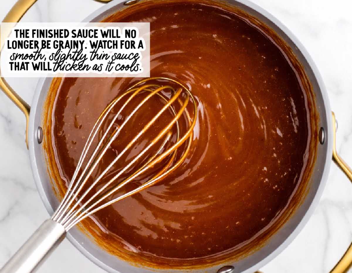 Smooth finished brown sugar sauce in a saucepan with whisk showing glossy texture