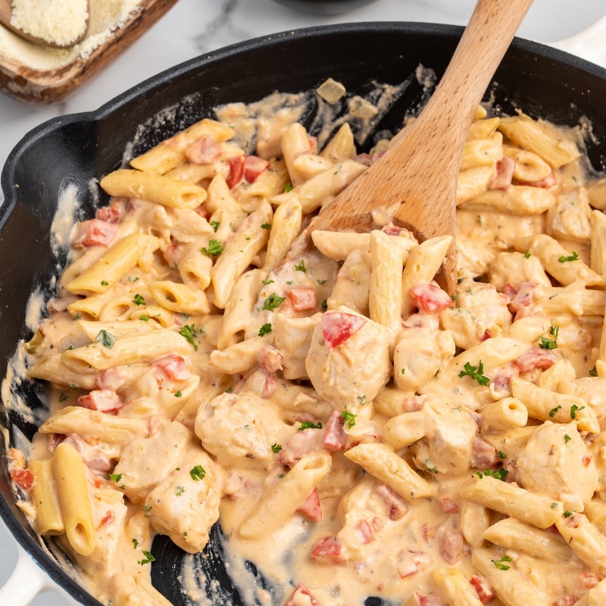 close up shot of a pot of Cajun Chicken Pasta garnished with parsley