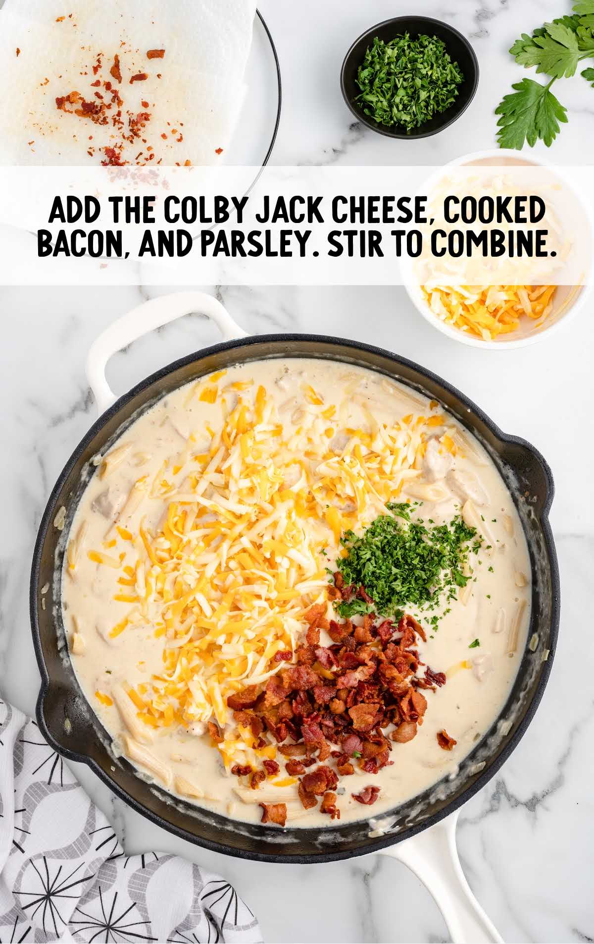 colby jack cheese, bacon, and parsley added to the skillet