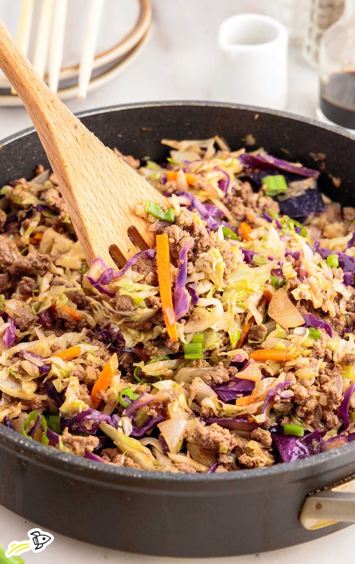 a close up shot of Crack Slaw in a skillet with a wooden spoon