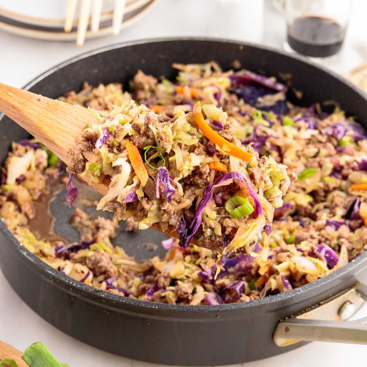 a close up shot of Crack Slaw in a skillet with a wooden spoon