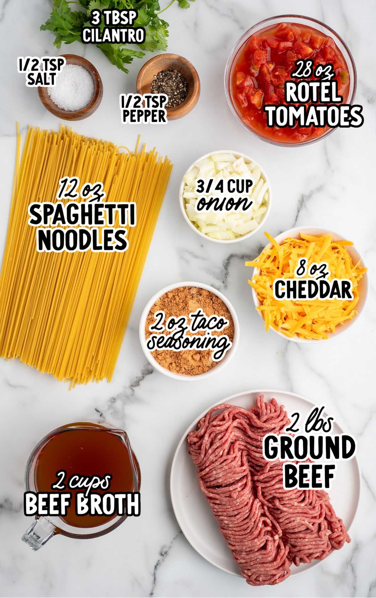 Ingredients for crockpot taco spaghetti including ground beef, spaghetti noodles, Rotel tomatoes, cheddar cheese, and taco seasoning