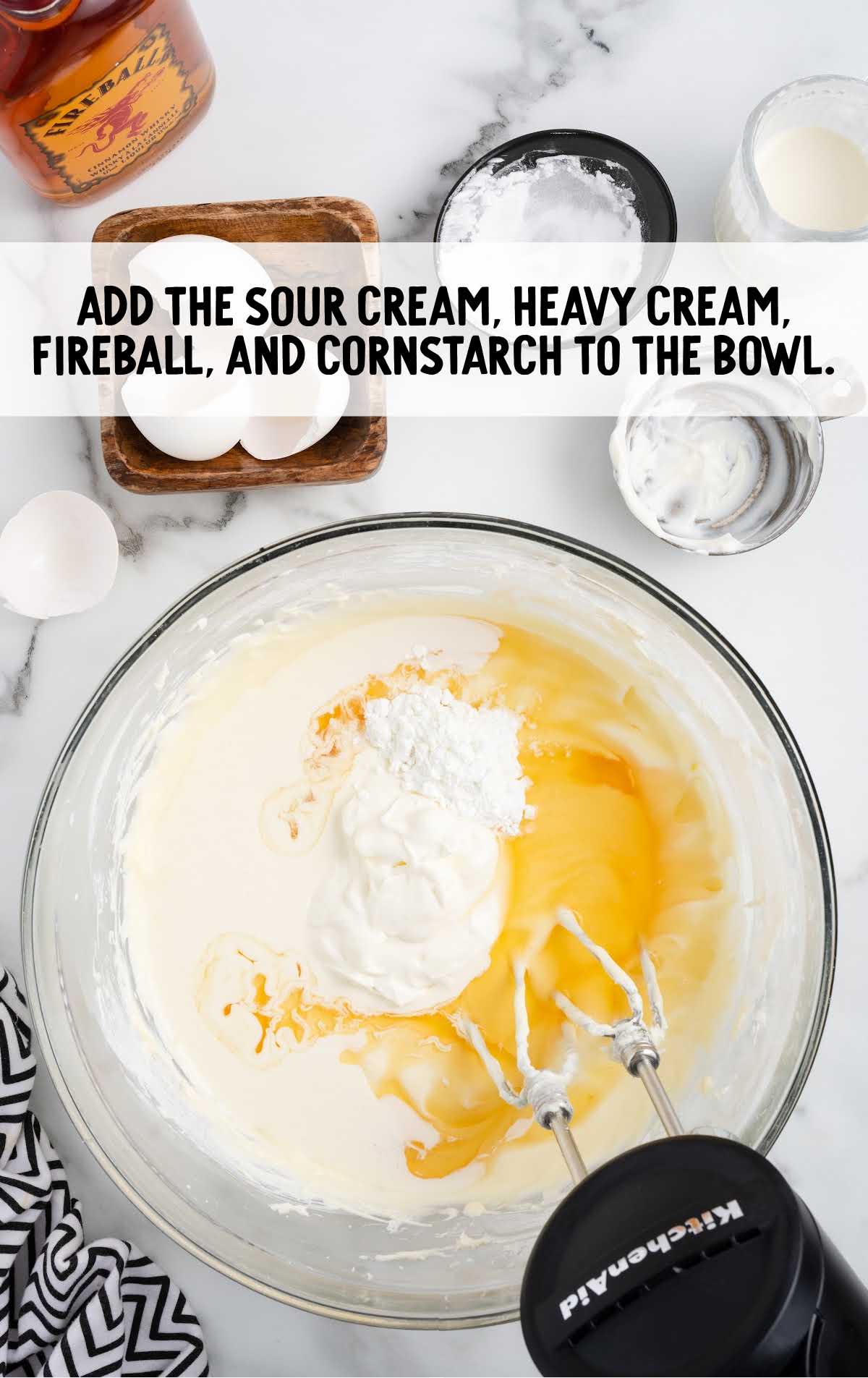 sour cream, heavy cream, fireball, and cornstarch added to a bowl