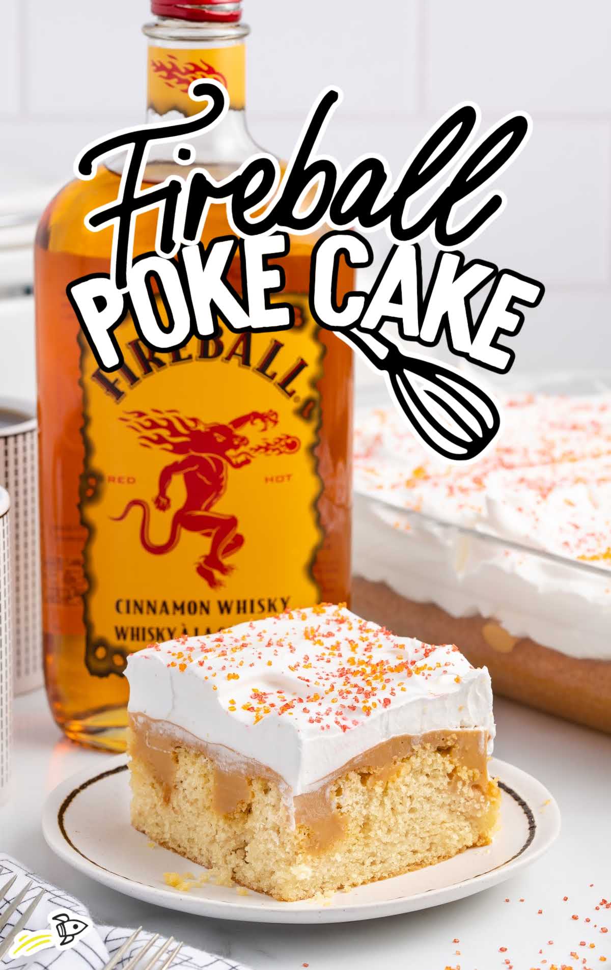 close up shot of a cake on a plate with a fireball bottle in the background