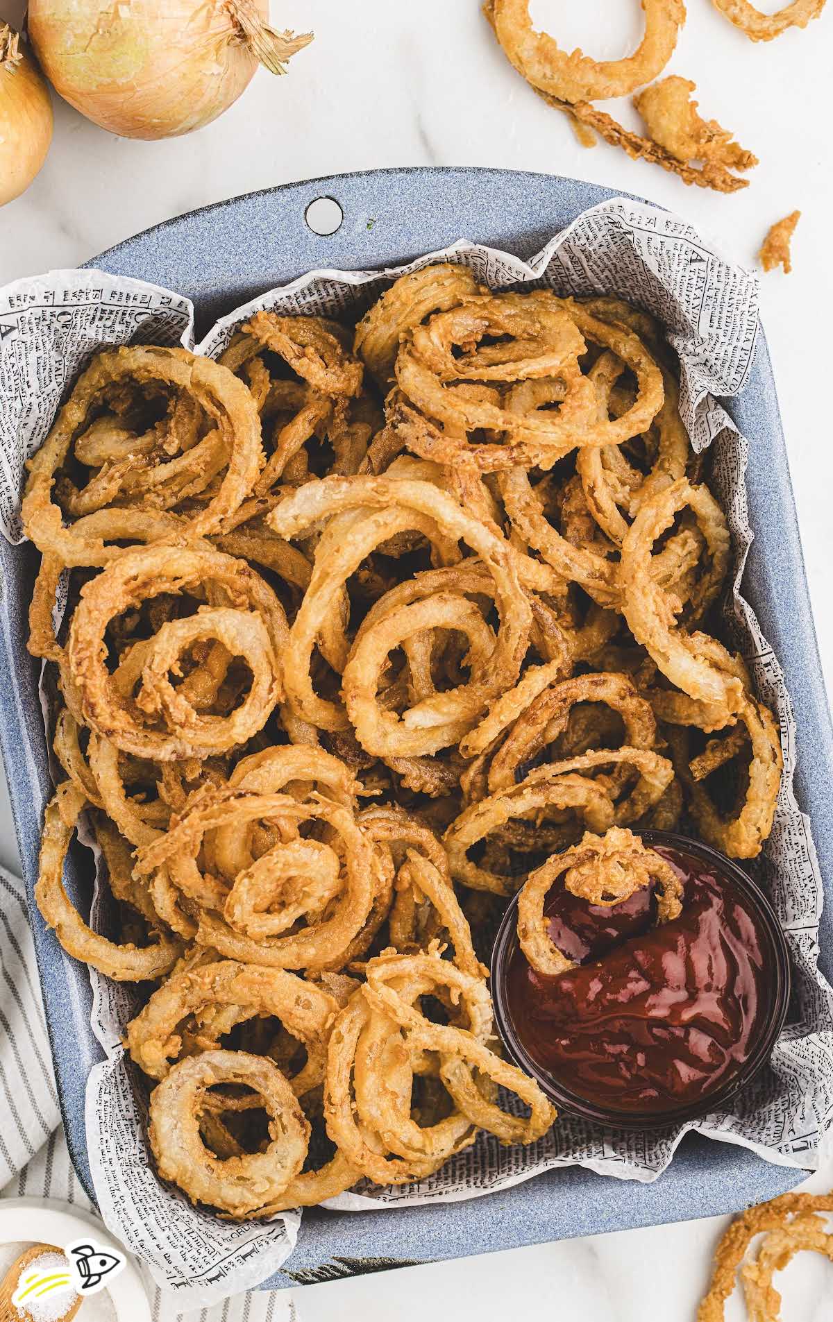 overhead shot of Frizzled Onions in a tray with a side of sauce