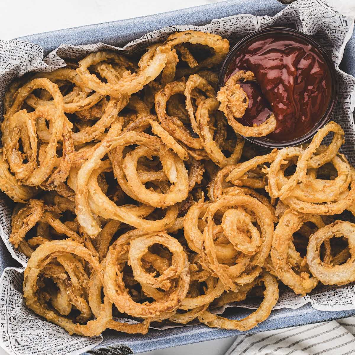 overhead shot of Frizzled Onions in a tray with a side of sauce