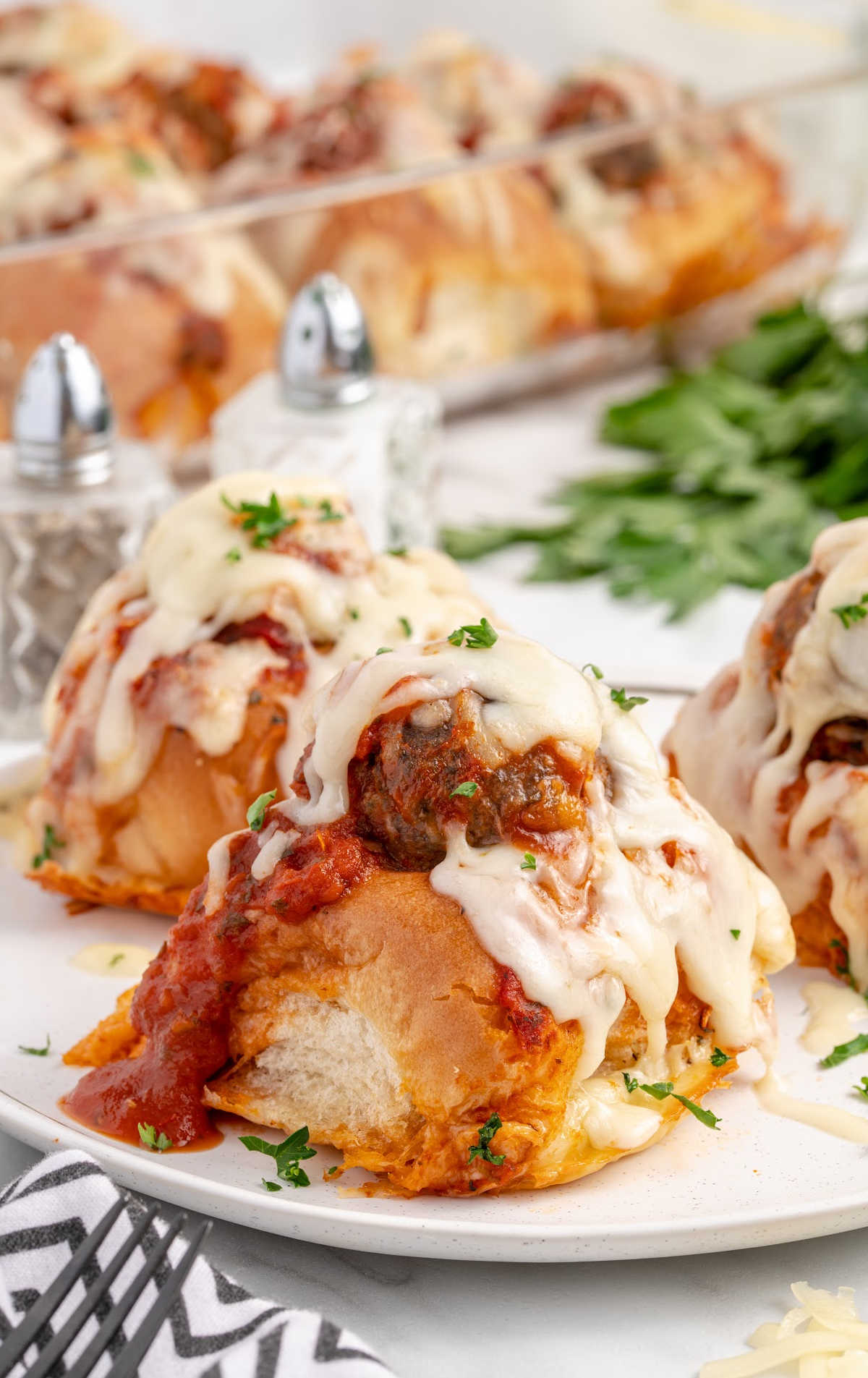 close up shot of garlic bread meatballs garnished with parsley on a plate