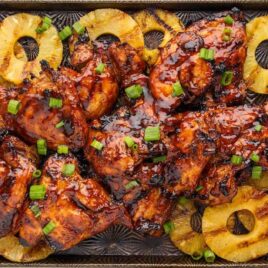 a baking tray of Huli Huli Chicken with slices of pineapples