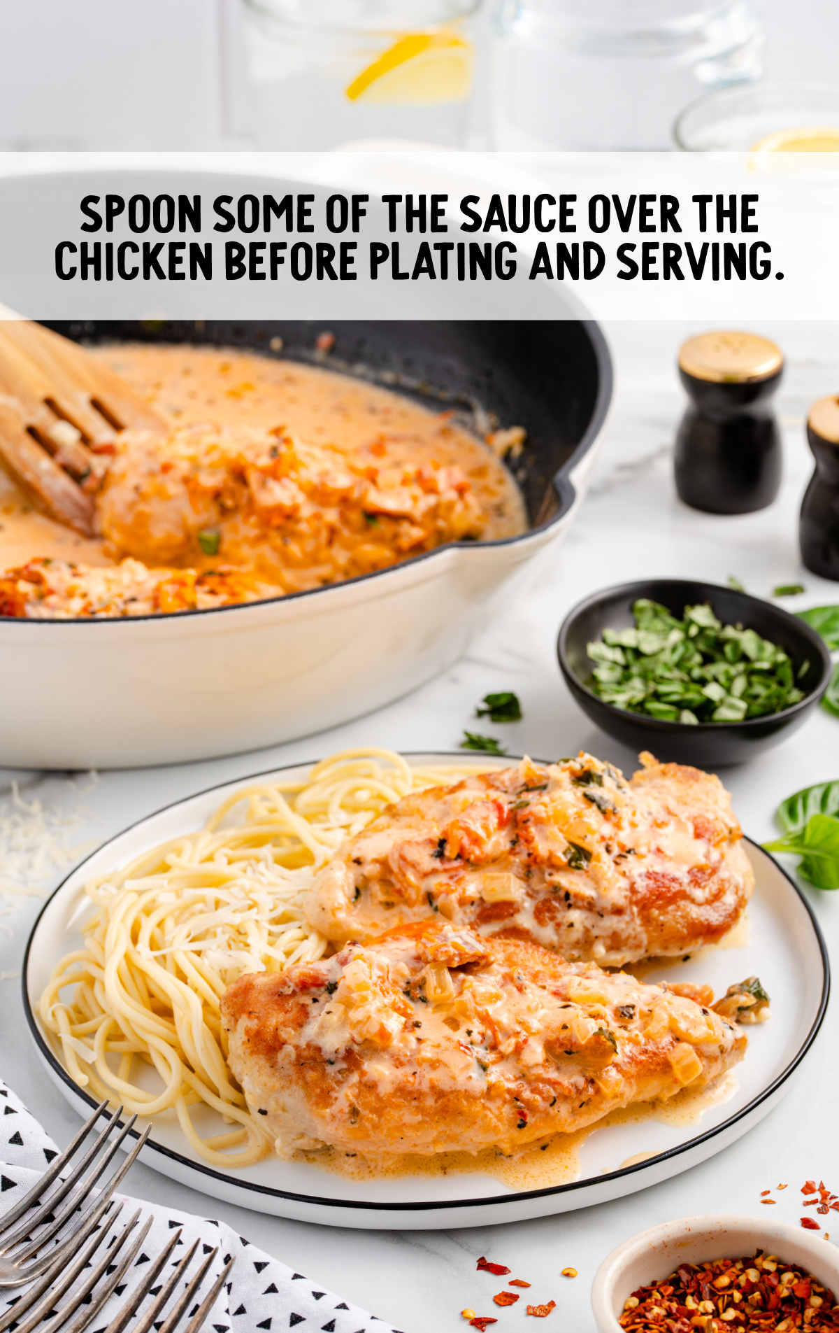 a dinner plate of pasta and chicken with the sauce spooned over top.