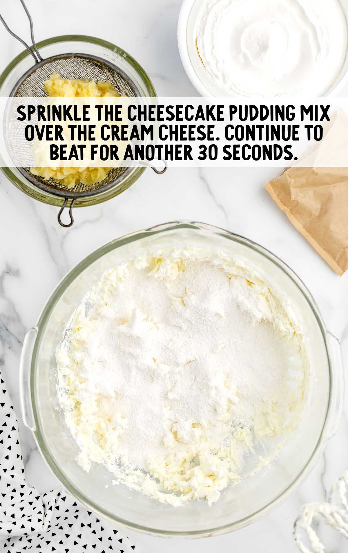 cheesecake pudding mixed sprinkled over the cream cheese in the bowl