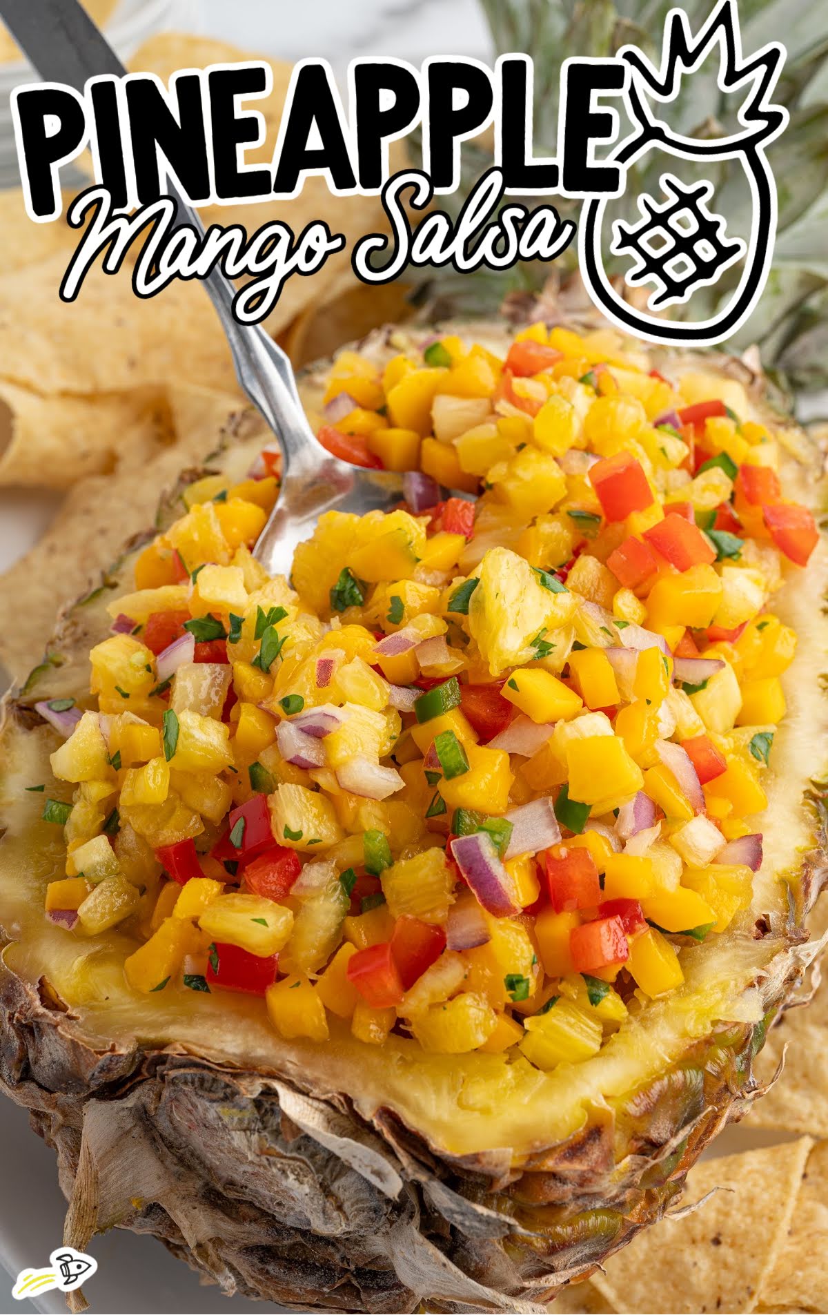 Pineapple mango salsa served in a pineapple half, with a spoon ready to scoop. Bright, juicy ingredients like mango, pineapple, red onion, and red bell pepper are clearly visible. "Pineapple Mango Salsa" text and a graphic pineapple icon are overlaid on the image.