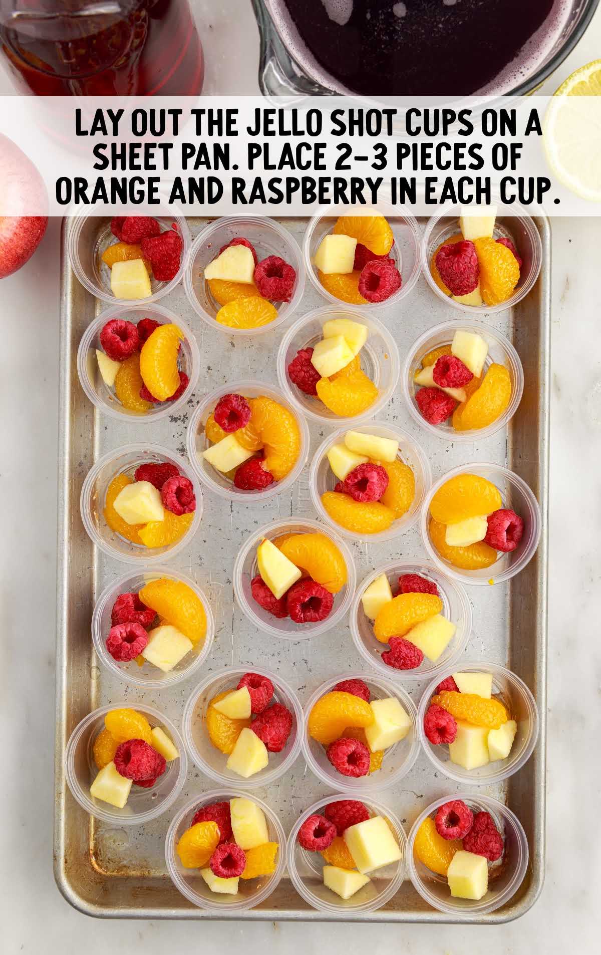mandating oranges and raspberries placed into the jello shot cups
