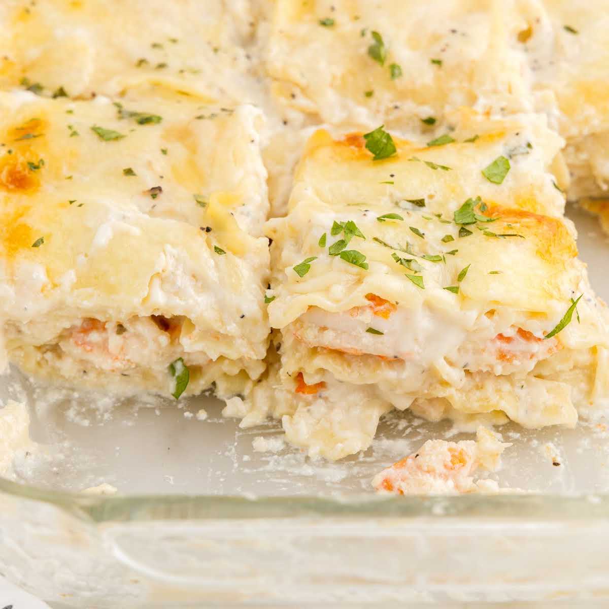 close up shot of Seafood Lasagna in a baking dish with a couple of slices taken out