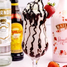 close up shot of Strawberry Mudslides topped with chocolate sauce, whipped cream, and a strawberry