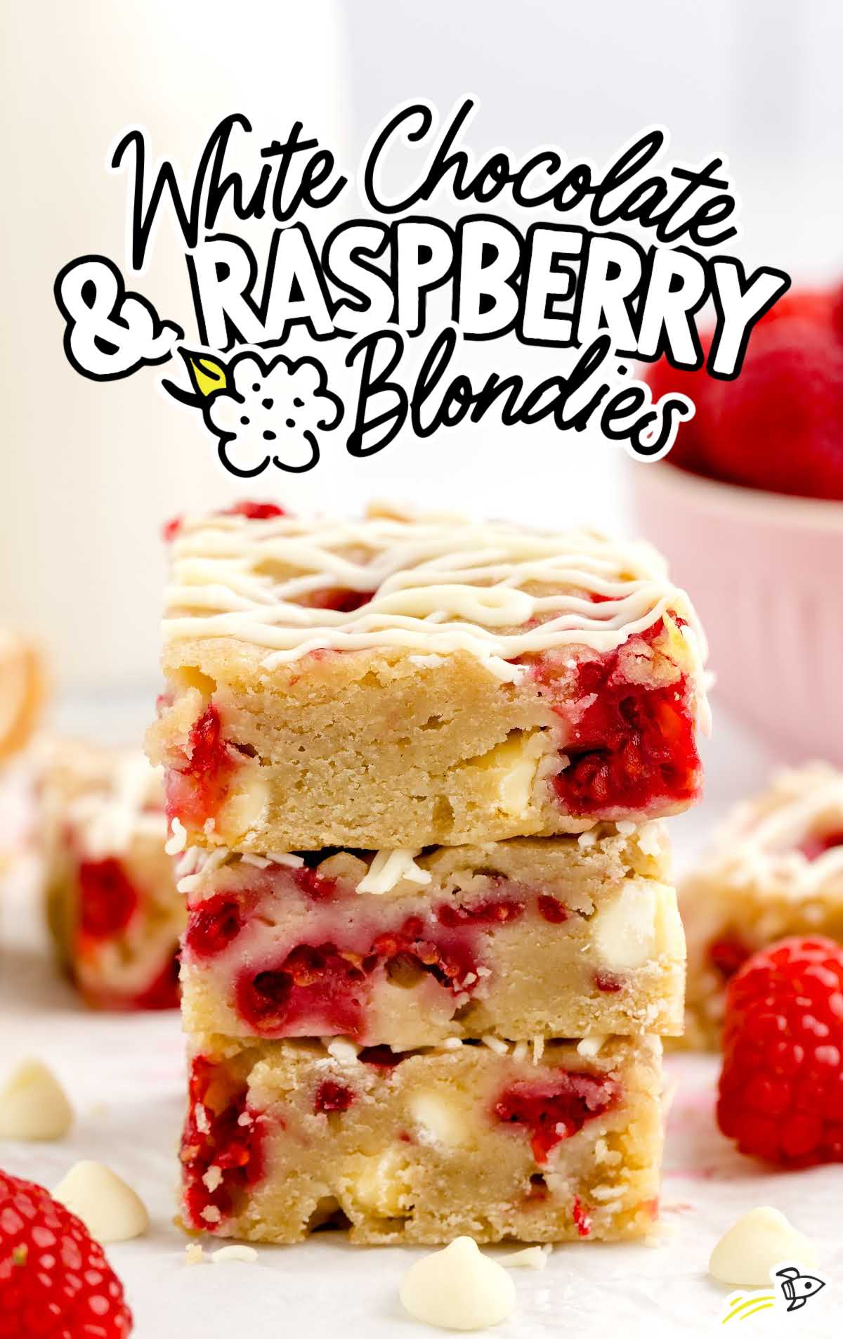 a close up shot of White Chocolate And Raspberry Blondies stacked on top of each other