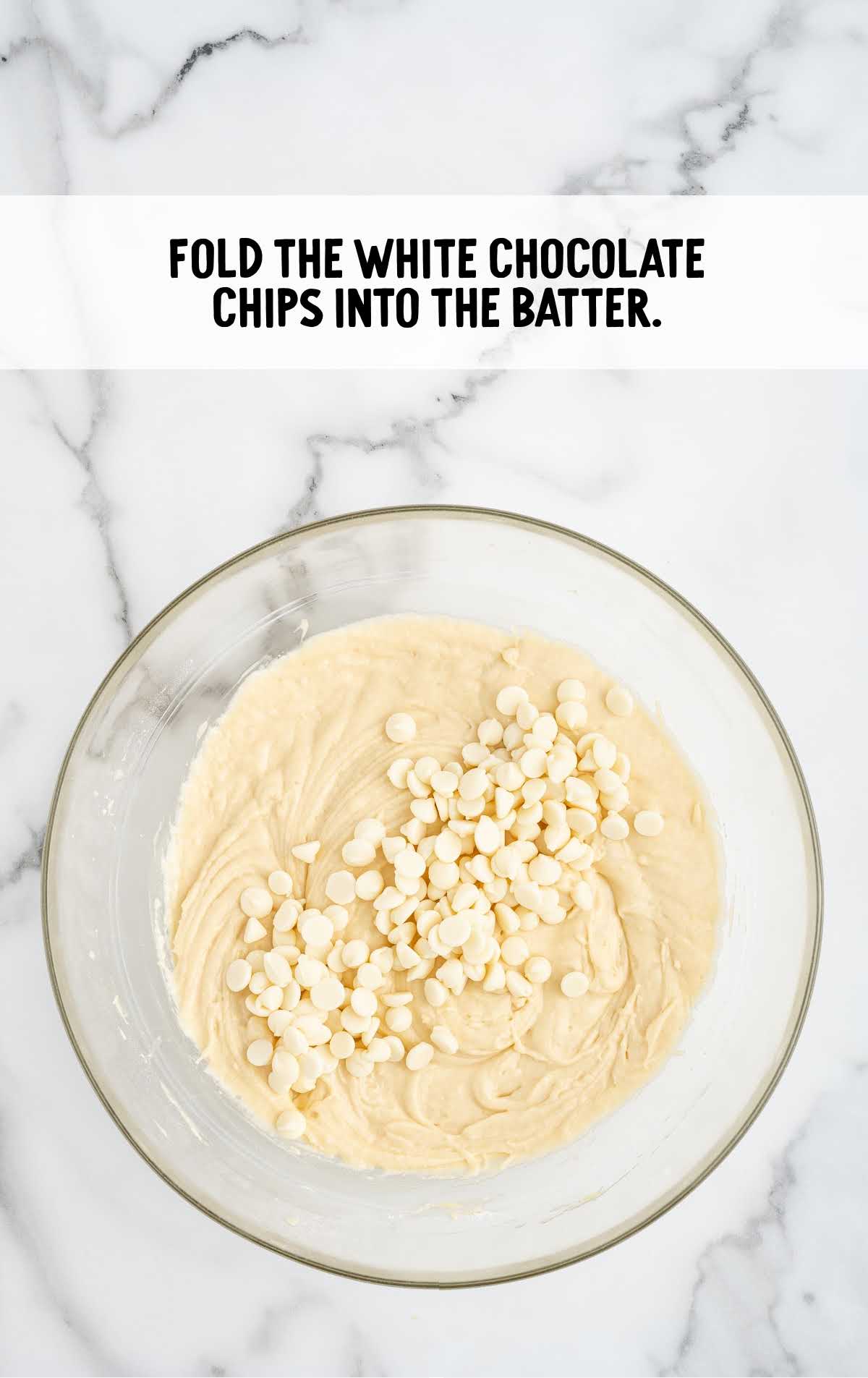 white chocolate chips folded into the muffin batter in a bowl