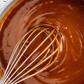 Brown sugar sauce being whisked in a saucepan with text overlay about serving over pancakes and crepes