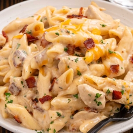Cheesy crack chicken penne made with chicken breast, ranch seasoning, and bacon, shown with ingredient packages.
