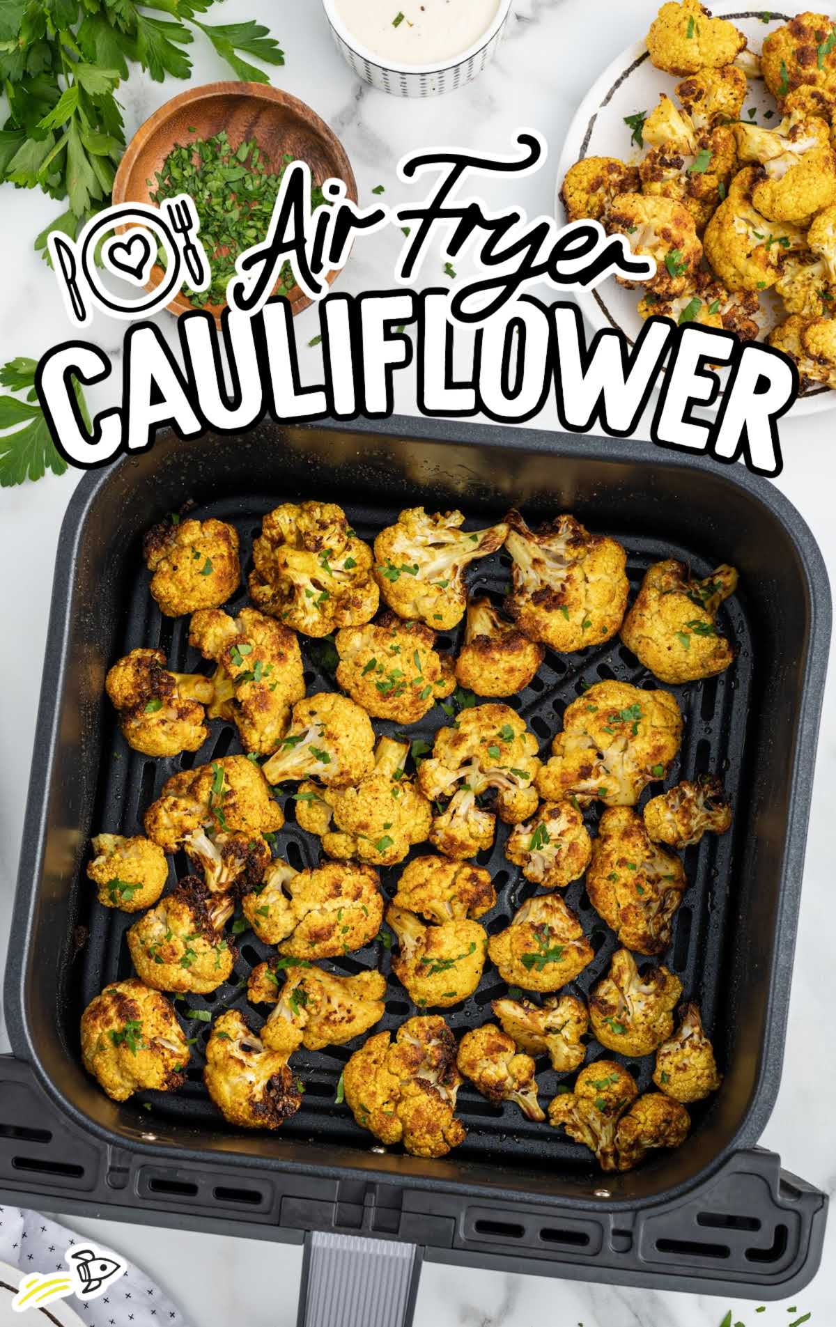 overhead shot of cauliflower garnished with parsley in a air fryer