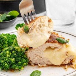 Cheese Stuffed Chicken Breasts garnished with basil on a plate