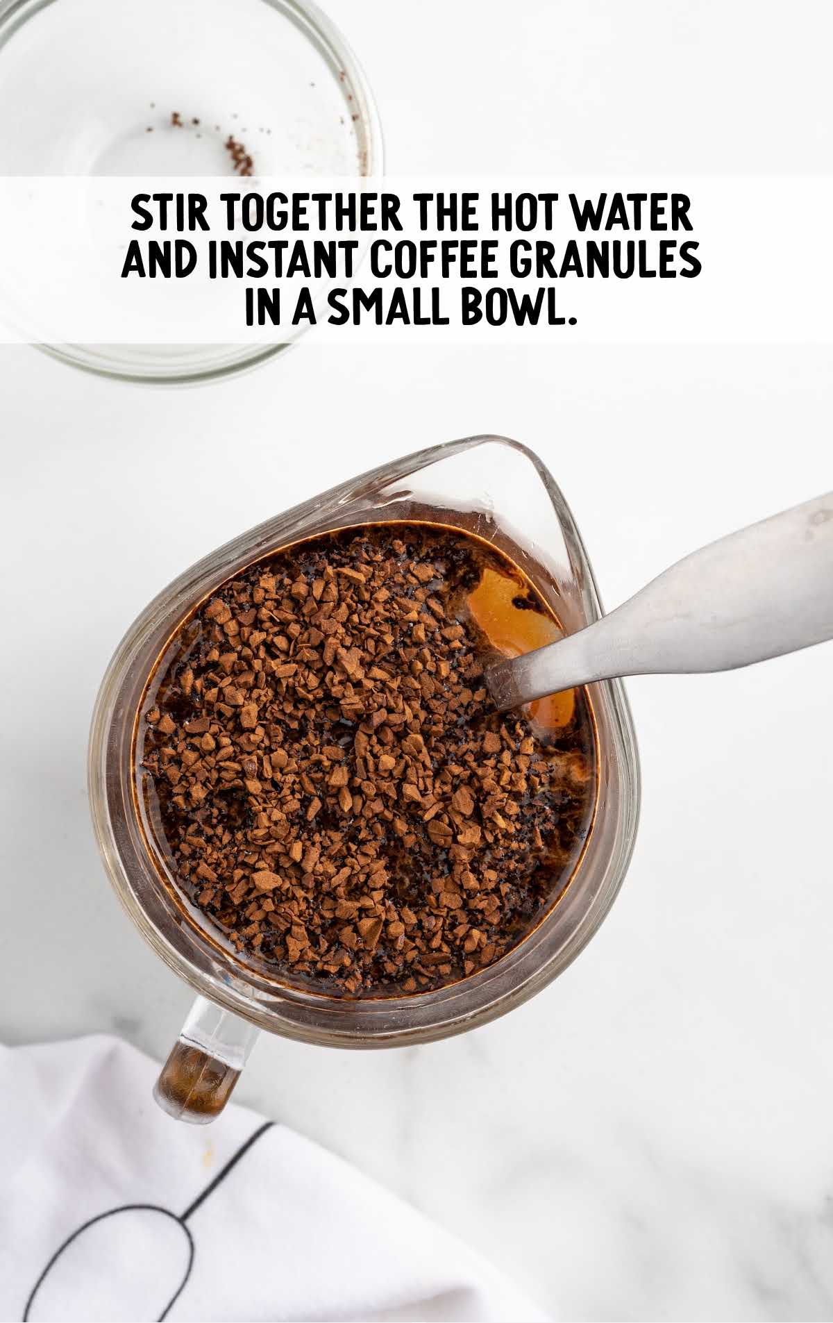 hot water and instant coffee granules combined in a bowl 