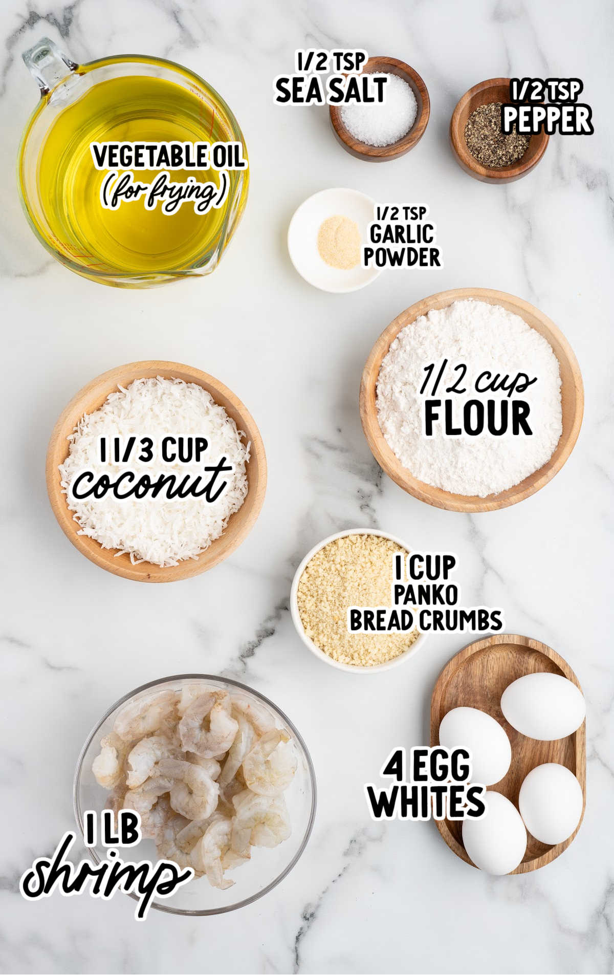 Ingredients for coconut shrimp including shrimp, coconut, panko breadcrumbs, flour, egg whites, and seasonings