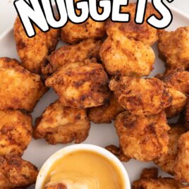 a plate of chicken nuggets with a bowl of dipping sauce