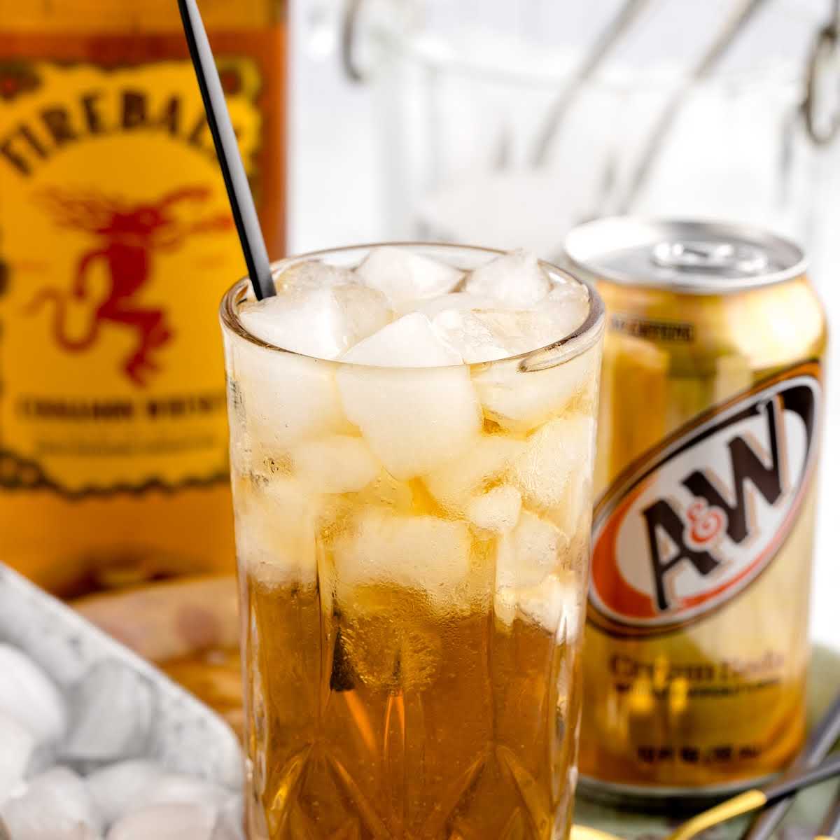 a glass of Fireball and Cream Soda with ice and a straw