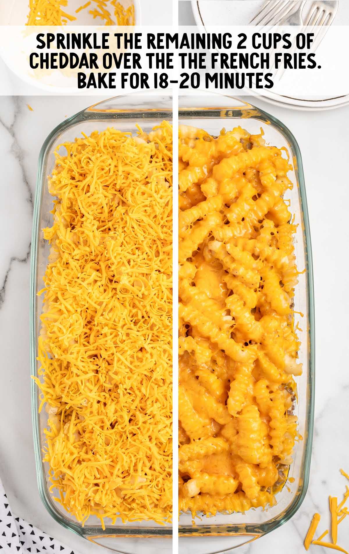 cheddar cheese sprinkled on top of the French fries in a baking dish